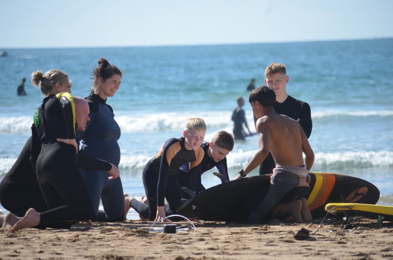 Mohamed coaching a surf group on the beach in Taghazout